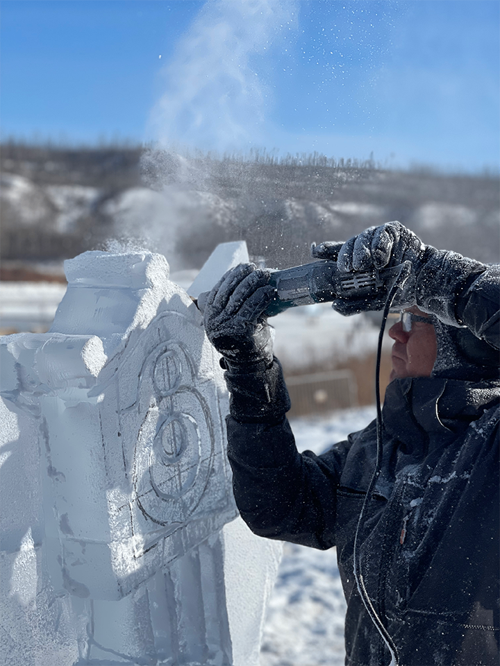 Sculptor carving Stranger Things clock with ice spray flying